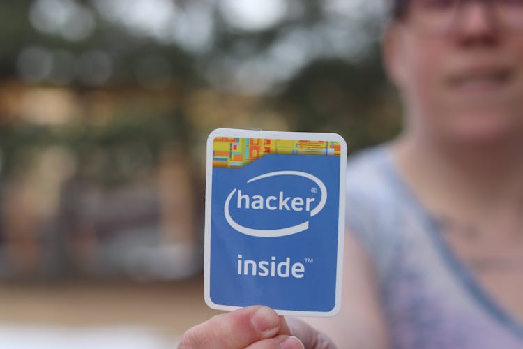 A Person Holding White And Blue Sticker