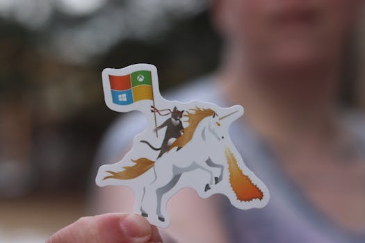 Sticker featuring a unicorn with a colorful flag, held by an adult outdoors.