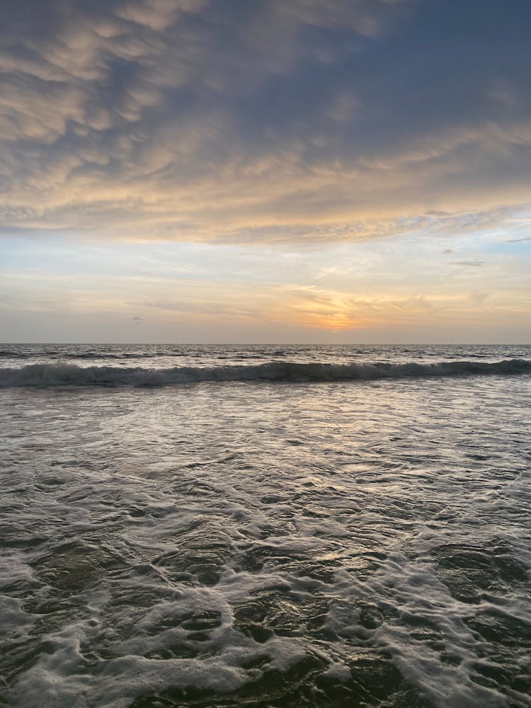 Ocean Waves Crashing On Shore During Sunset