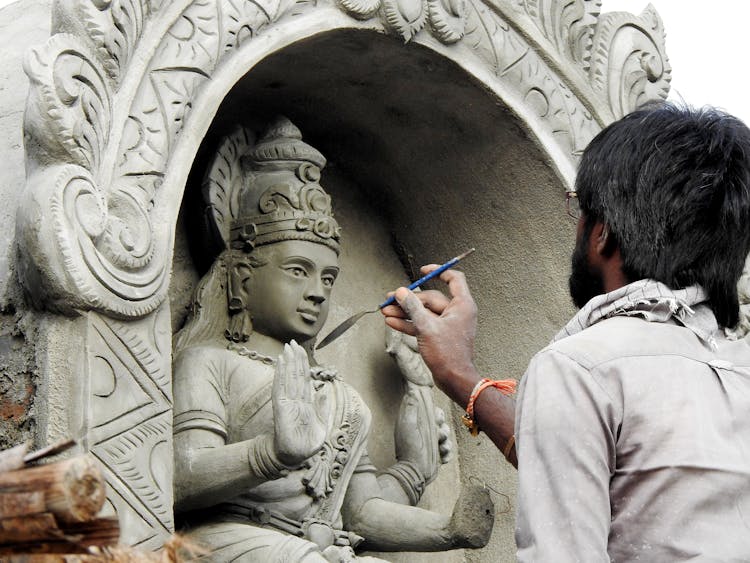 Man Renovating Buddha Sculpture