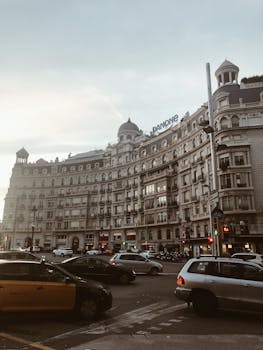 Capture of a historic building and bustling city scene in Barcelona's urban landscape at sunset.