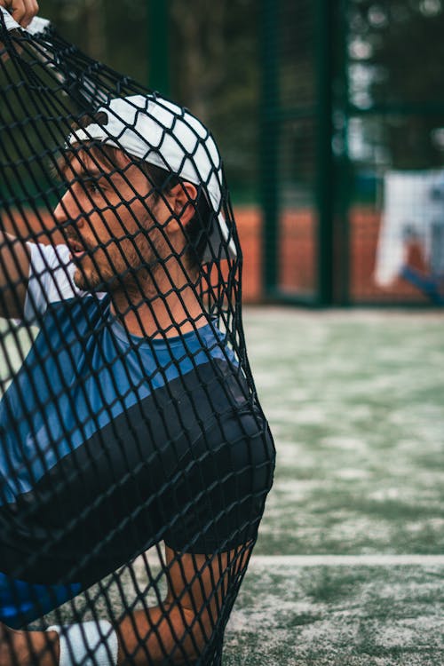 Person Sitting on Grass Holding Goal Net