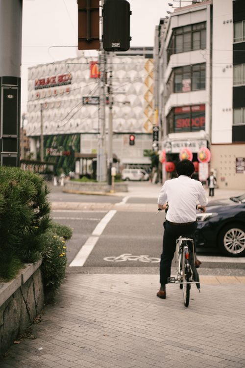 Free Man cycling through a bustling city intersection, capturing urban commute essence. Stock Photo