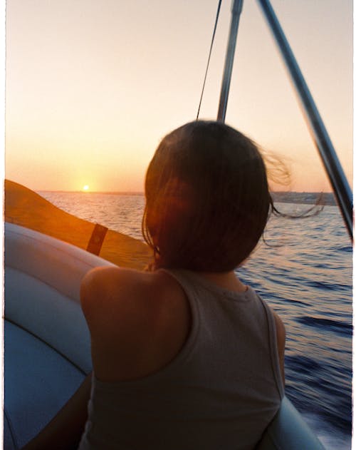 A Woman in a Tank Top Riding a Boat