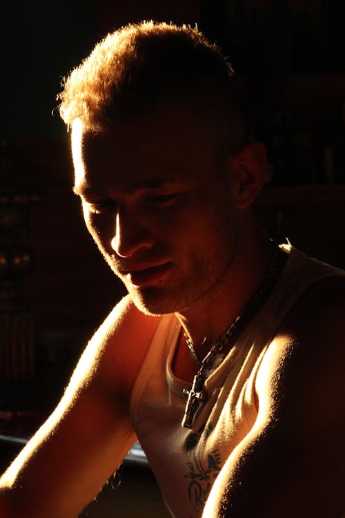 A Man in a Tank Top Wearing a Cross Necklace