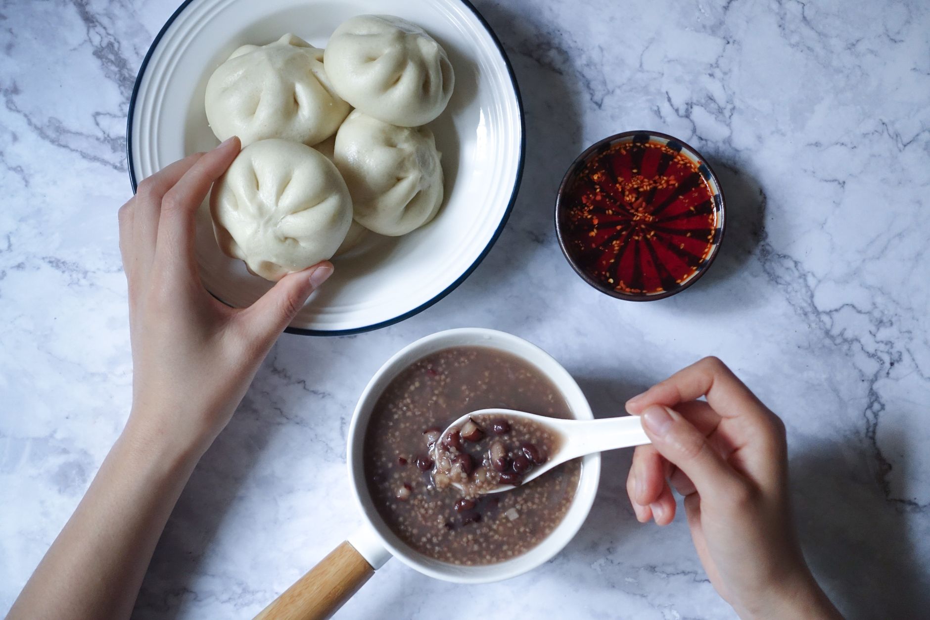 旅行鍋煮粥可行嗎?新手不焦底技巧一次掌握 A top-view of a traditional Asian breakfast featuring steamed buns and red bean porridge.
