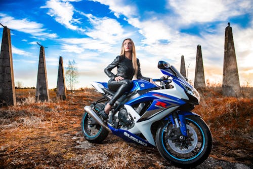 Free Woman In Black Leather Jacket Sitting On Blue And White Suzuki Gsx-r Stock Photo