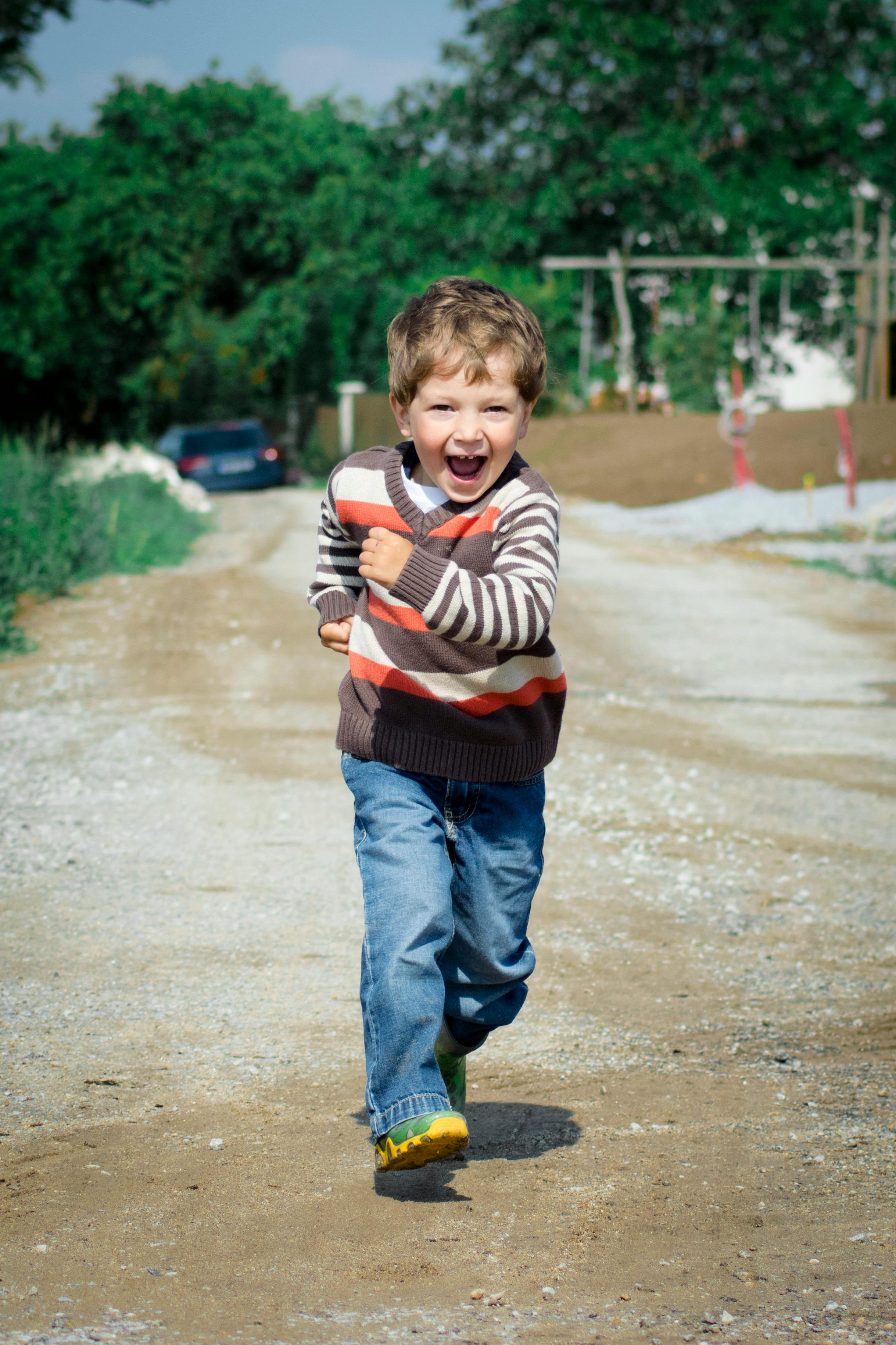 Happy little boy running outdoors in the park. | Photo: Pexels