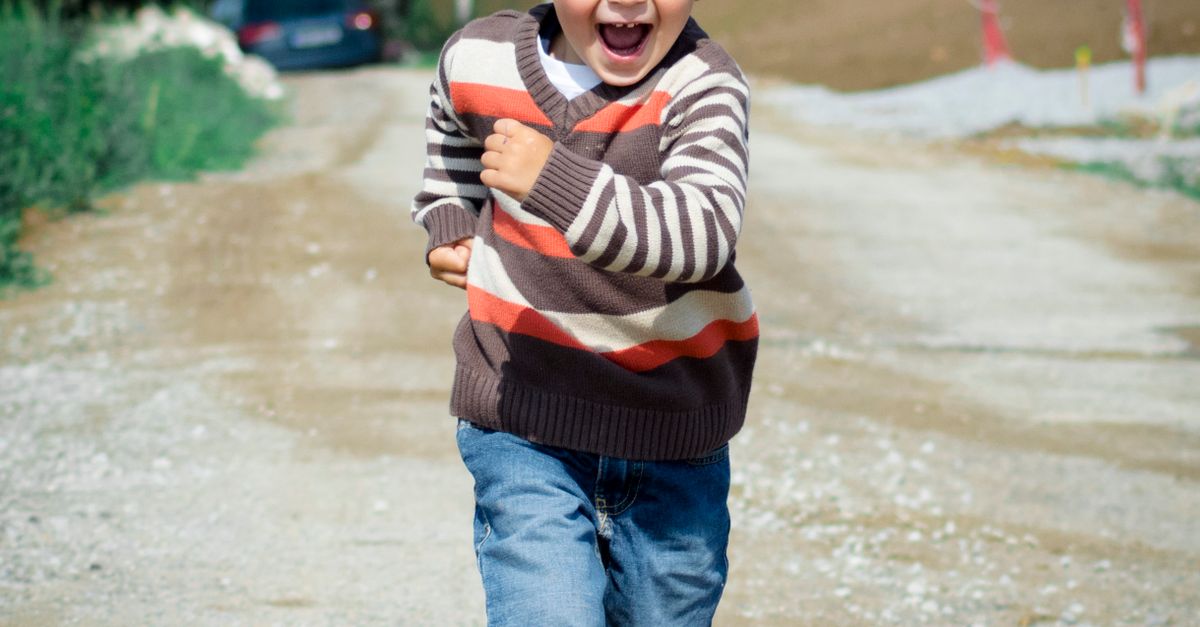 A child wearing sunglasses and smiling outdoors