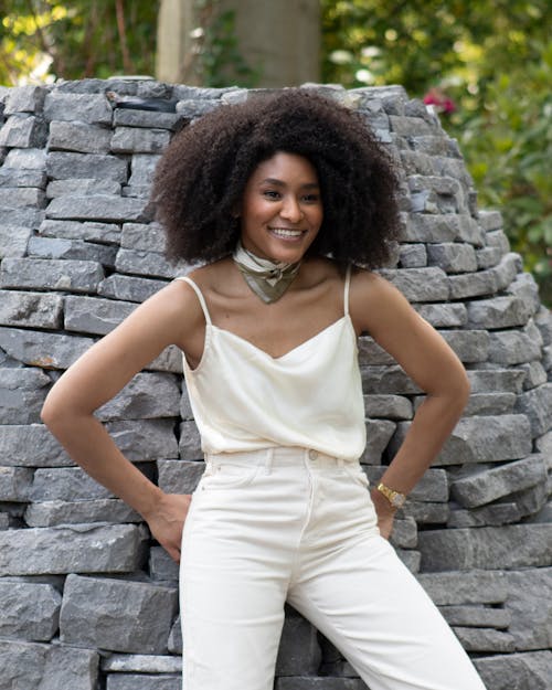 Woman in White Tank Top and White Pants Smiling