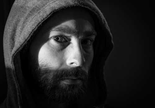 Free Close-up black and white portrait of a bearded man in a hood, capturing a moody atmosphere. Stock Photo