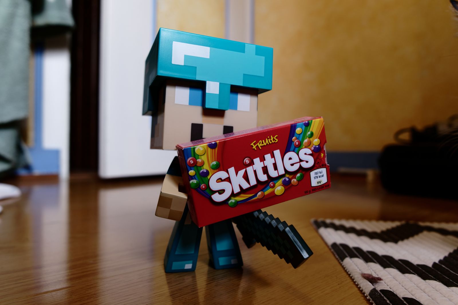 Blocky video game figurine in a diamond helmet holding a candy pack