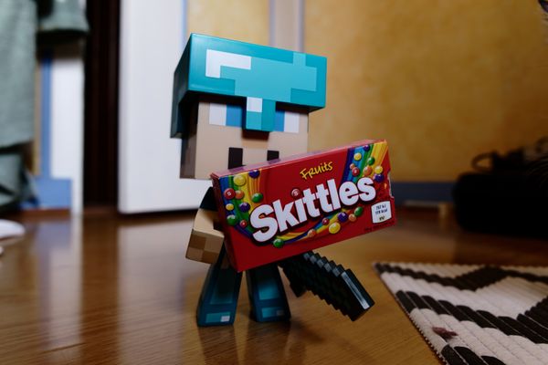 Figurine cubique de jeu vidéo au casque de diamant tenant un paquet de bonbons