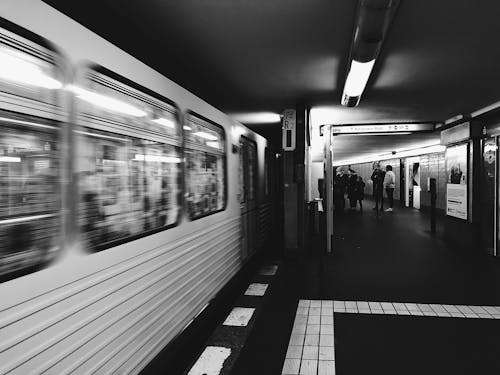 Free A Grayscale Photo of People on a Train Station Stock Photo