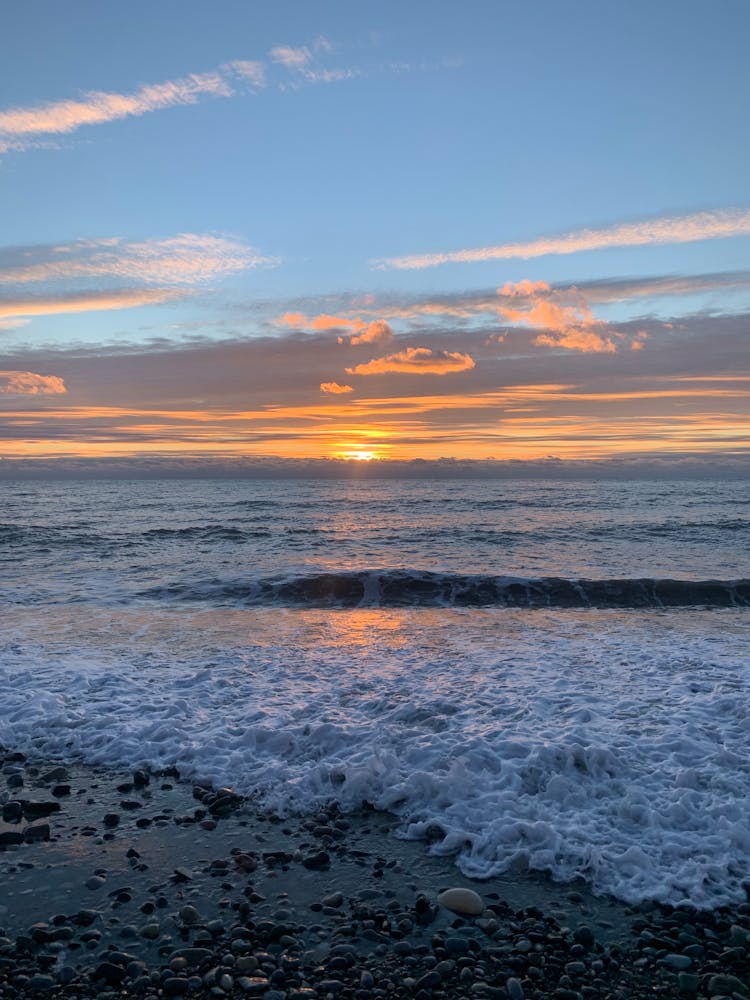 Ocean Waves Crashing On Shore During Sunset