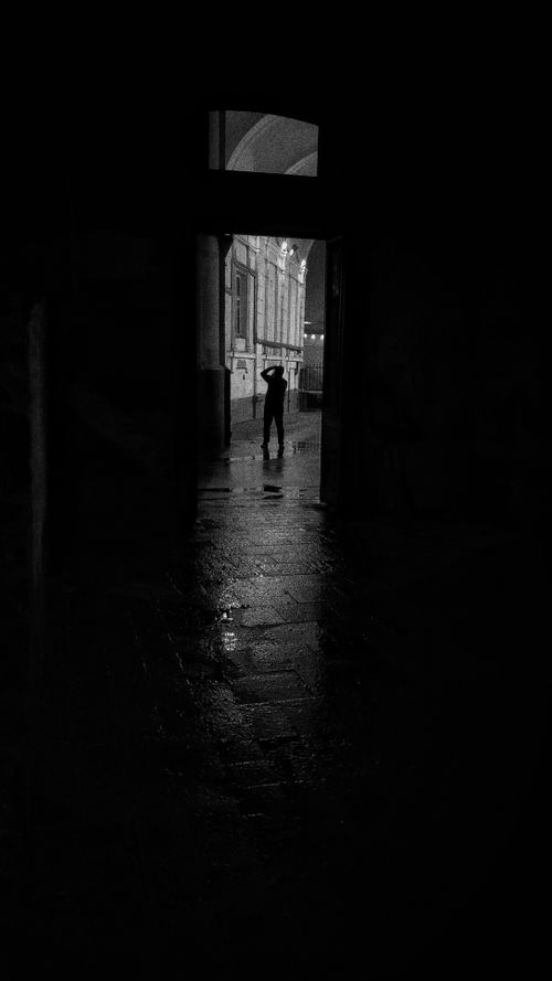 Free A mysterious silhouette of a person standing in a dark hallway creating an atmospheric scene. Stock Photo