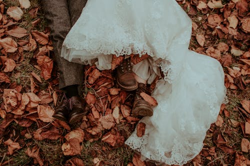 Free Bride and Groom Lying on Ground in Autumnal Leaves  Stock Photo