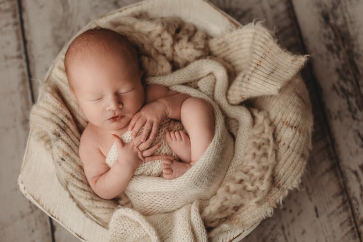 Cute Baby Wrapped With Knitted Blanket