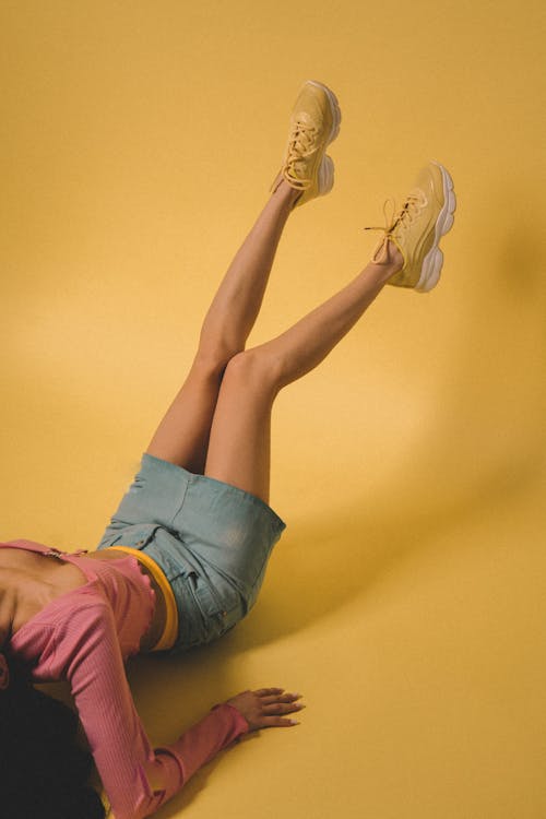 Female Legs Against Yellow Background