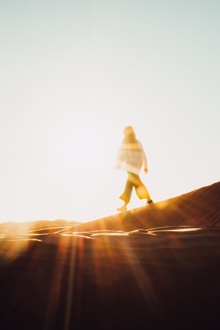 Silhouette Of Woman Walking On Desert