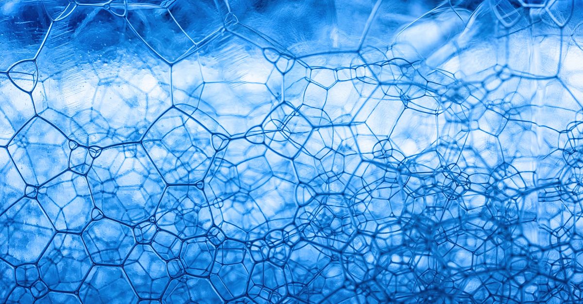 Detailed close-up of blue soap foam showcasing abstract geometric patterns and texture.
