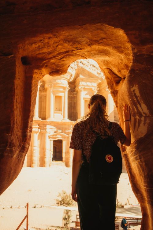 Free A female traveler exploring the ancient site of Petra, Jordan, from a desert cave. Stock Photo