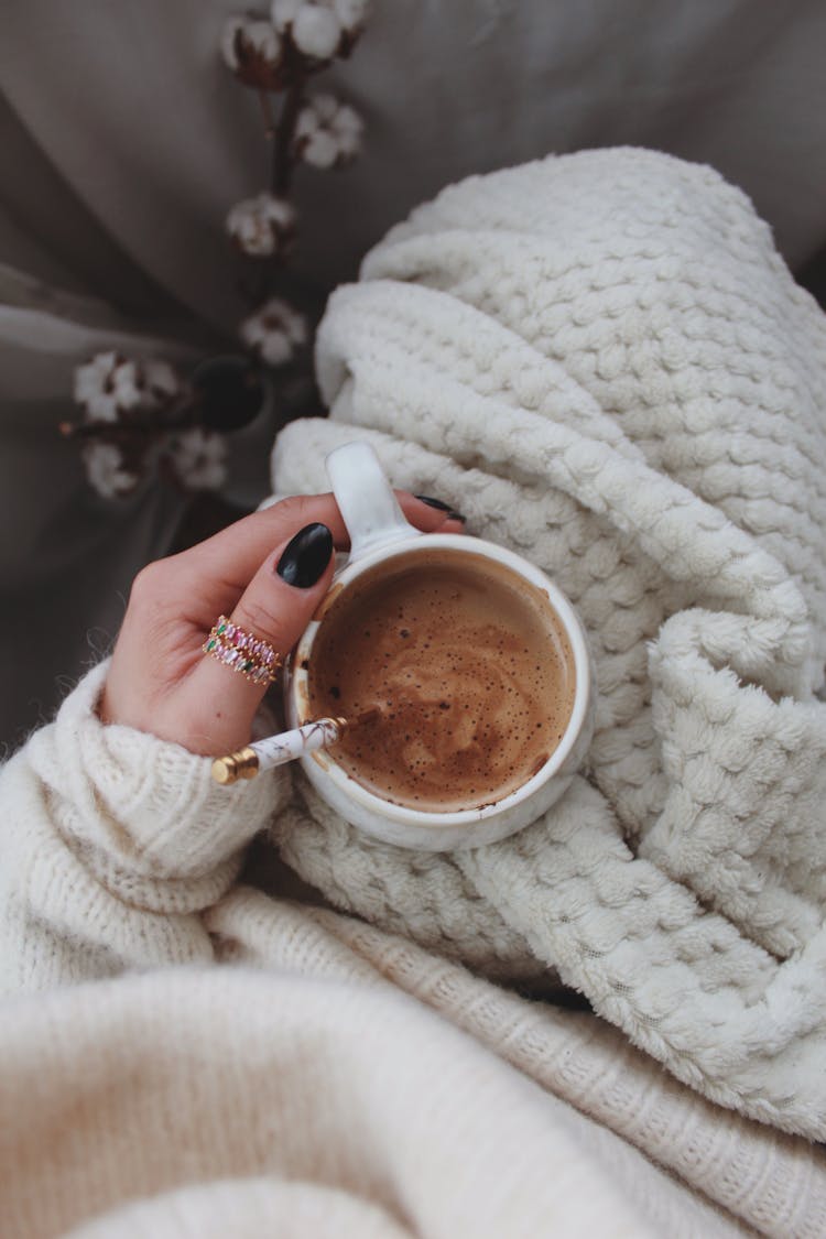 Directly Above View Of Hand Holding Coffee Cup