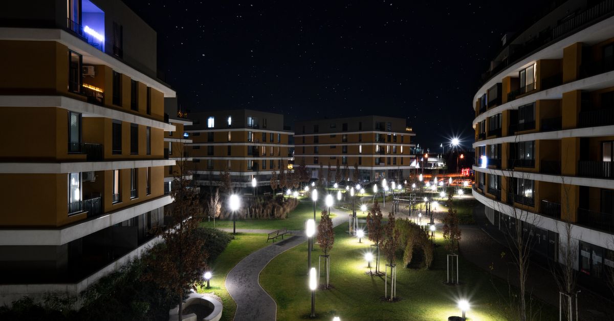 Illuminated modern apartment complex in Bratislava captured under a starry night sky.