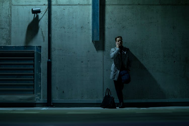 Man Leaning On Wall Talking On Phone