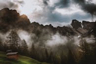 山间薄雾缭绕，木屋景色宁静，非常适合大自然爱好者