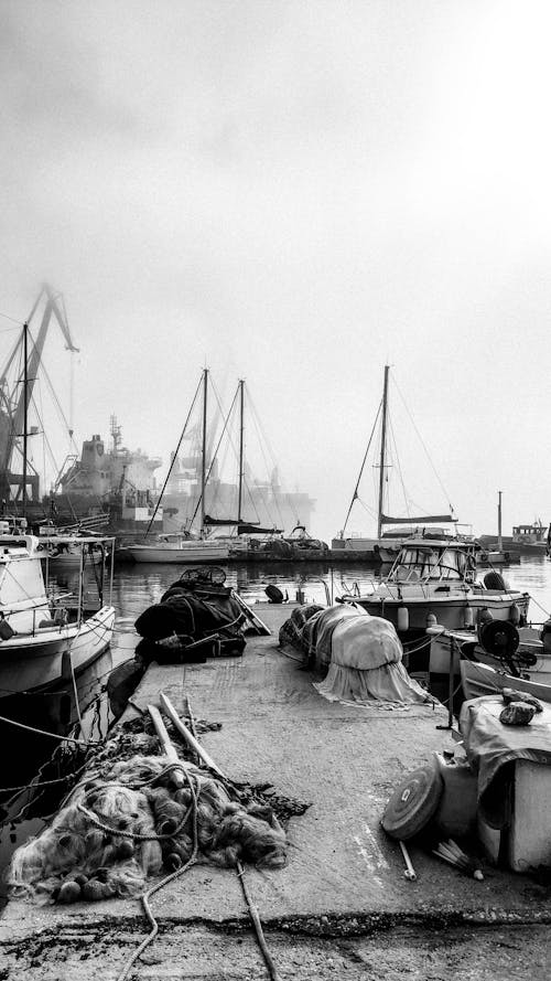 Grayscale Photo of Boats on Dock