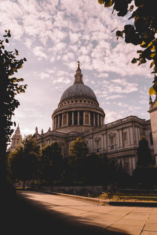 Free A beautiful shot of St. Paul's Cathedral surrounded by trees and a vibrant sky in London. Stock Photo
