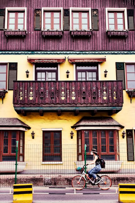 Vibrant facade with cyclist on urban street in Dongcheng Qu, Beijing, emphasizing architectural style.