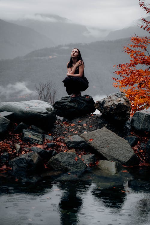 Woman Crouching on Rock