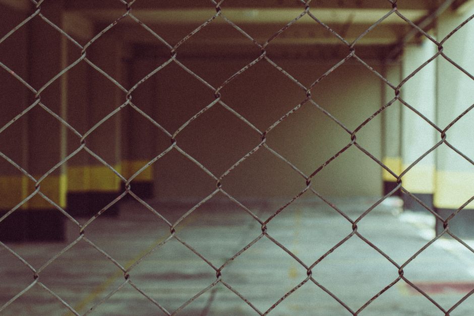 Blurred interior view through a chain link fence in industrial setting.