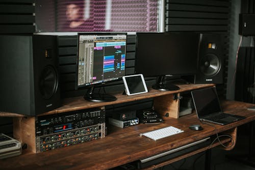 Computer Screens and Speakers on a Wooden Desk