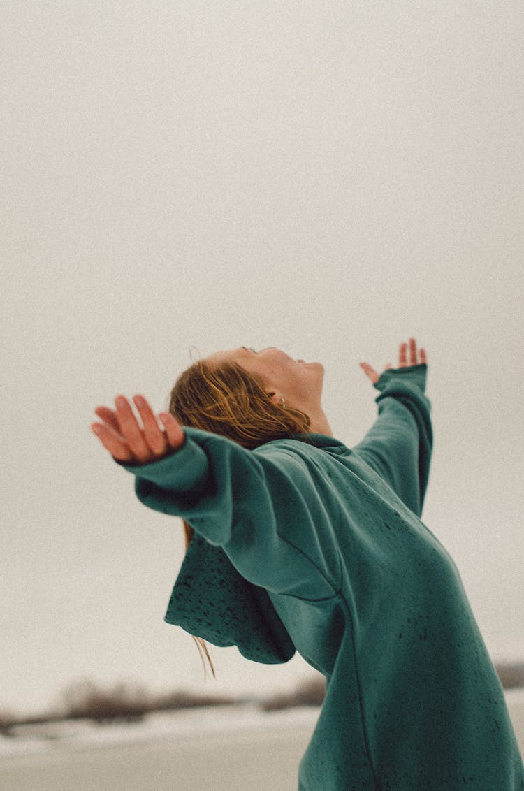 Woman In Teal Sweatshirt With Open Arms