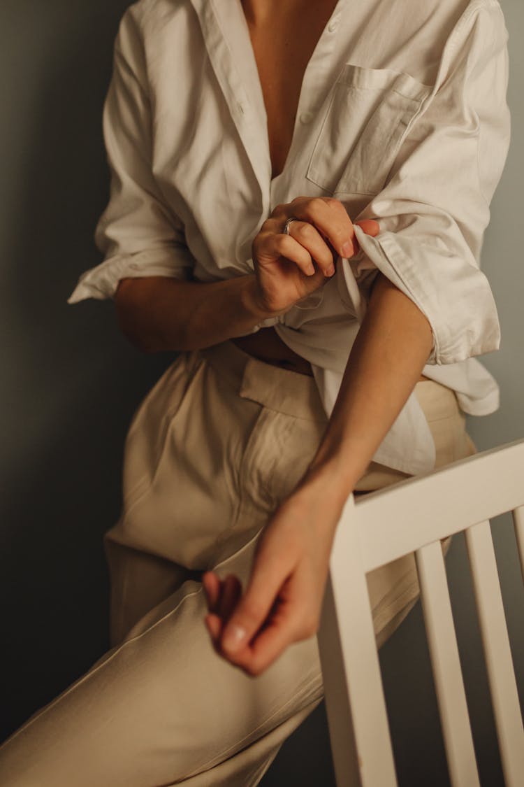 Unrecognizable Woman Rolling Up Sleeves Of White Blouse