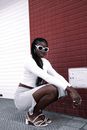 Crouching Afro-American Woman in White Costume Presenting Colour Contrast