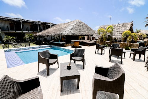 Brown Wooden Table and Chairs Near Swimming Pool