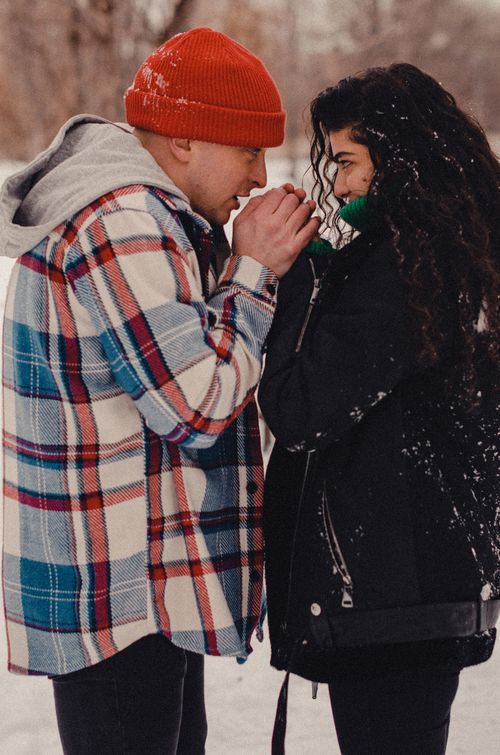 Free A loving couple sharing warmth and affection in a snowy winter setting. Stock Photo