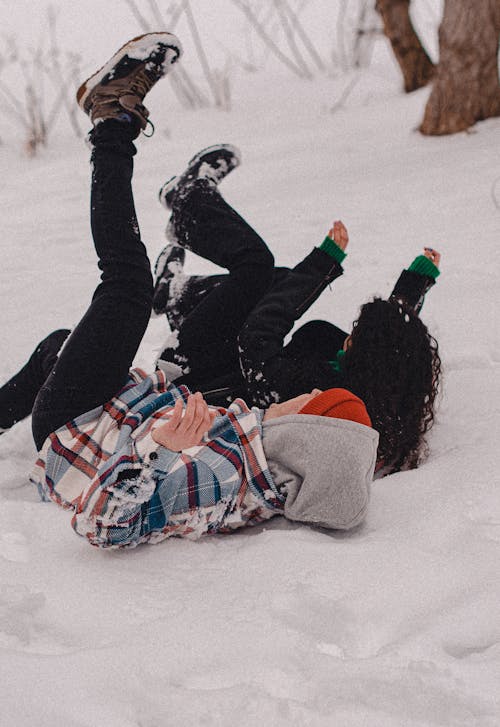 A Couple Lying Down on a Snow Covered Ground