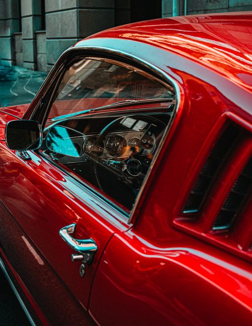 Free Close-up of a vintage red car showcasing its glossy finish and intricate details. Stock Photo