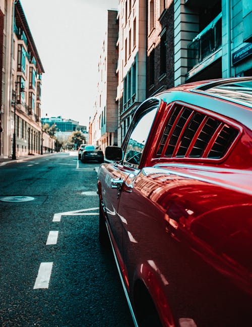 Photo of a Red Car Parked on the Side of the Road