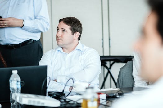Businessman attentively listening during a professional meeting in a modern office setting.