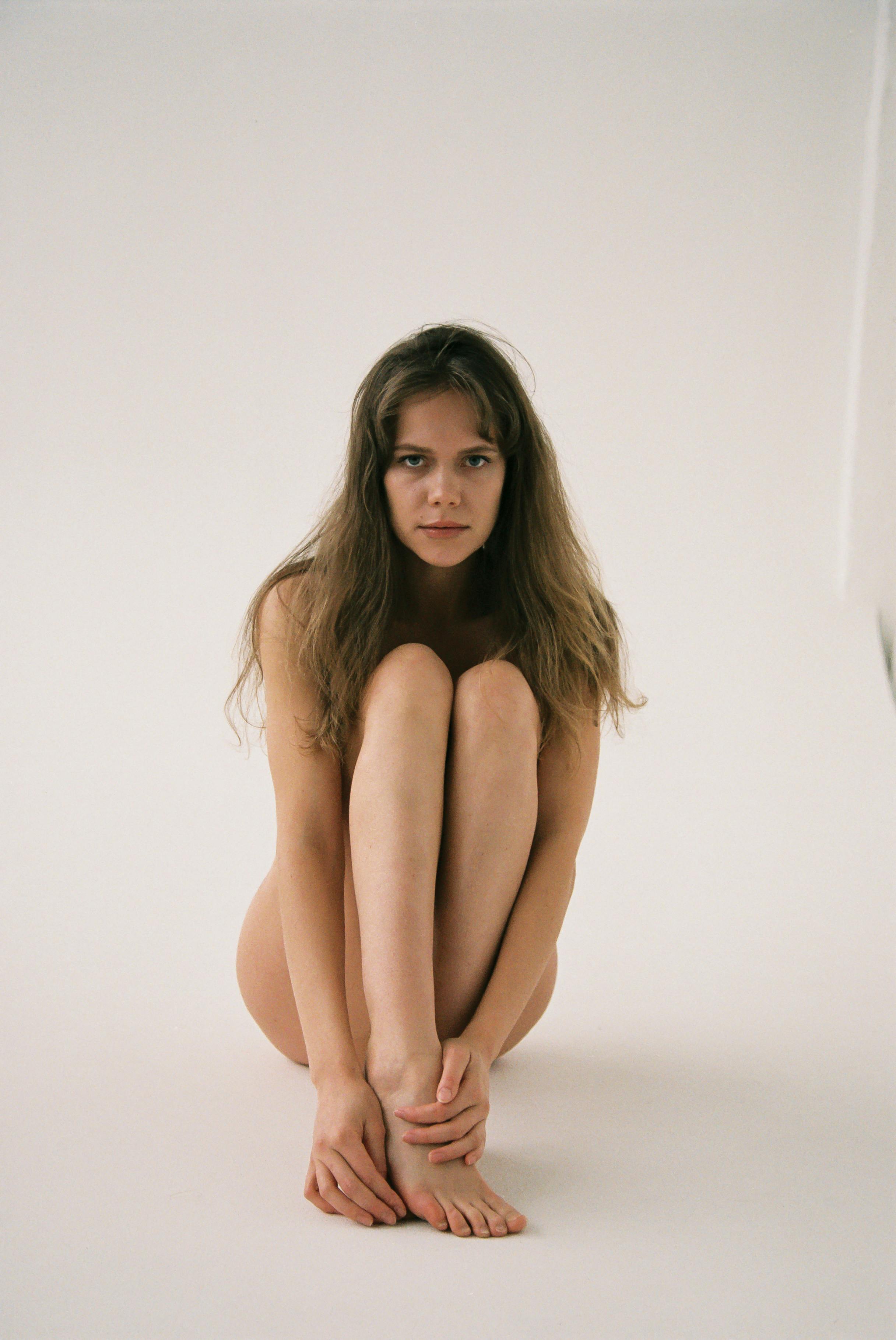 naked woman sitting on the floor