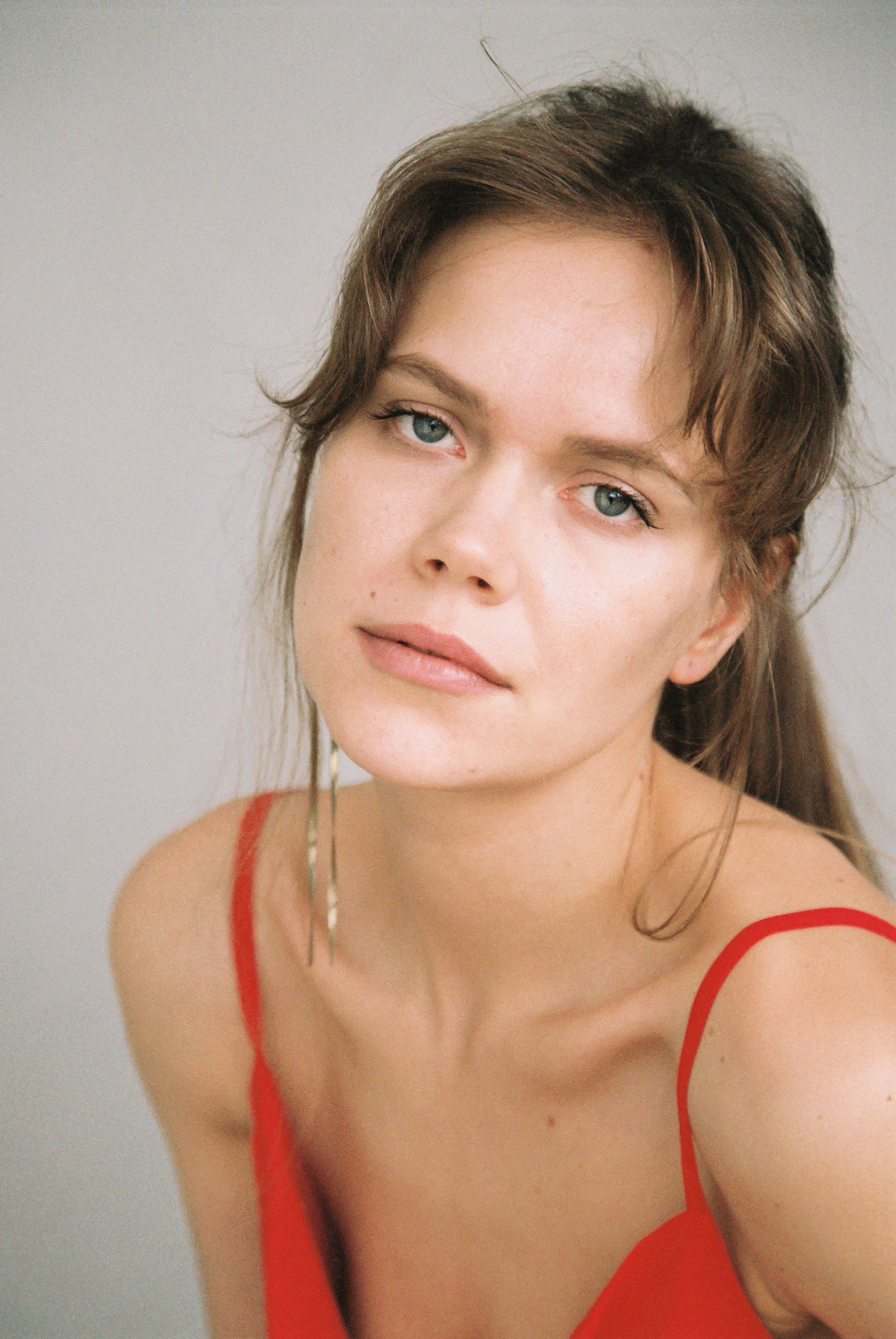 Captivating portrait of a woman in a red top with a serene expression, perfect for fashion and lifestyle themes.
