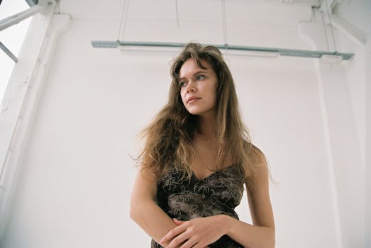 Portrait of a woman with long hair in a stylish dress in a modern minimalist room.