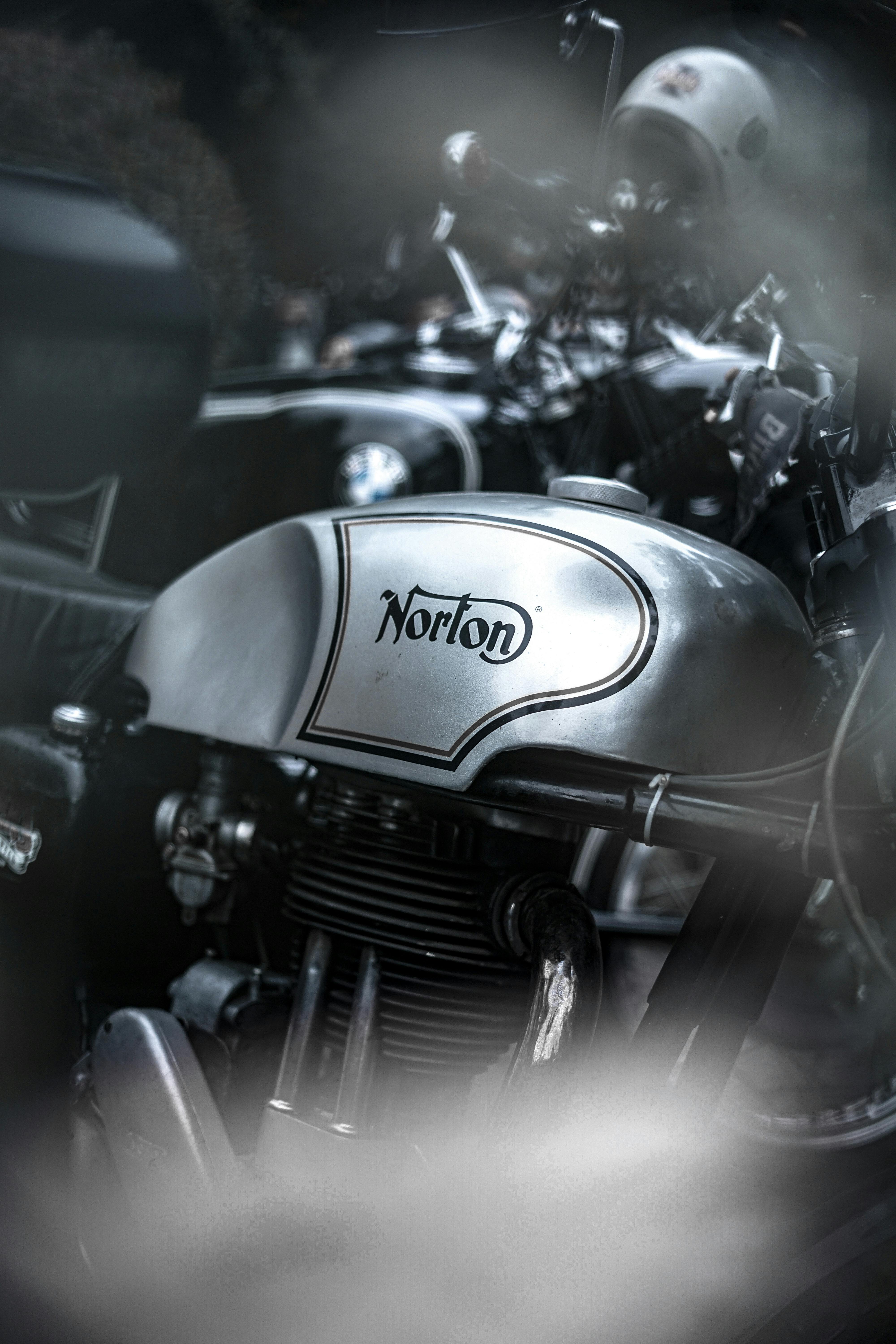 A detailed view of a classic Norton motorcycle gas tank, showcasing vintage design.