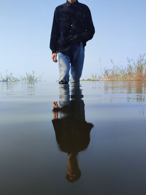 A Person in Black Long Sleeves Standing in the River